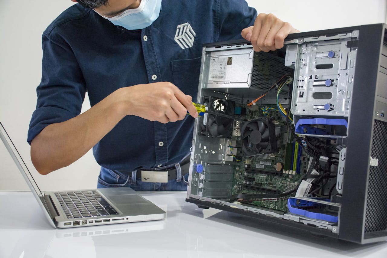 services-04 A technician repairs a desktop computer in an indoor setting, illustrating tech maintenance.